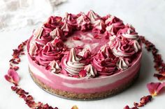 a cake with pink frosting and flowers around it