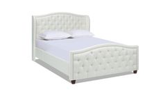 a white bed with an upholstered headboard and pillows on top of it