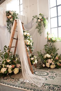 a ladder decorated with flowers and greenery