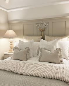 a large bed with white pillows and blankets