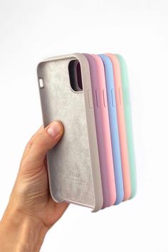 a hand holding an iphone case with five different colors