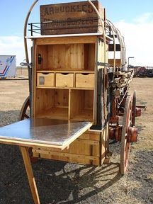 an old fashioned wooden cart with drawers on it's back and wheels attached to the side