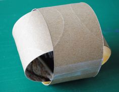 a roll of brown paper sitting on top of a green table next to a piece of cake