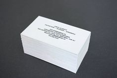 a stack of business cards sitting on top of a black table next to each other