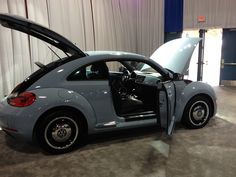 a gray car with its door open on display