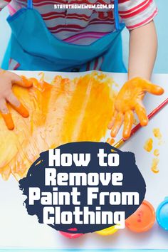 a child is painting with yellow paint on the paper and holding it in his hands