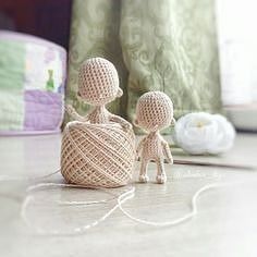 two small crocheted figures sitting next to each other