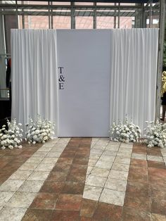 the entrance to a wedding ceremony with white flowers and drapes