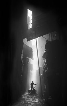 a black and white photo of a person in a boat