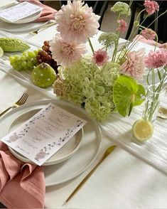 the table is set with flowers and place settings for guests to enjoy their meal together