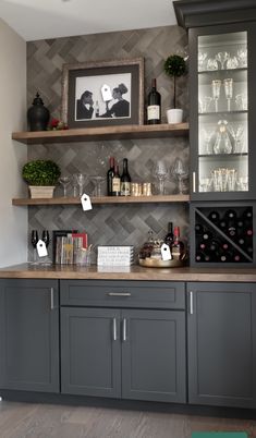 a kitchen with gray cabinets and shelves filled with wine glasses