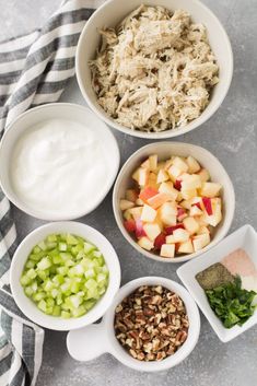 bowls filled with different types of food sitting on top of a white and gray table