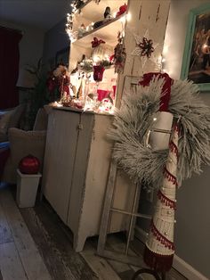 a christmas tree is decorated with lights and garlands in the corner of a living room