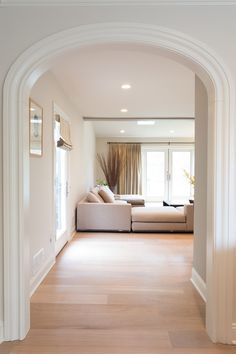 an archway leading to a living room with a couch and table in the corner on one side