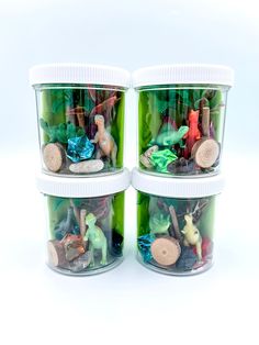 three plastic containers filled with different types of toy figurines and toys in them