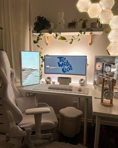 a computer desk with two monitors and a white chair in front of the monitor screen