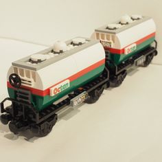 two lego train cars sitting side by side on a white surface with no people around them