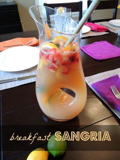 a pitcher filled with fruit sitting on top of a table