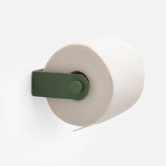 a roll of toilet paper hanging from a green hook on a white wall next to a roll of toilet paper