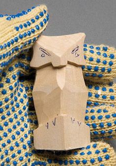 a close up of a knitted object with blue dots on it and a piece of wood sticking out of the top