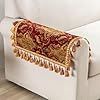 a white chair with a red and gold blanket on it's armrests