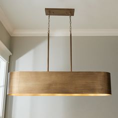 a wooden light fixture hanging from a ceiling in a room with gray walls and white trim