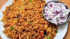 a white plate topped with rice next to a bowl of coleslaw