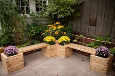 a wooden garden bench sitting in the middle of a yard with flower pots on it