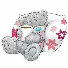 a teddy bear with a cup of coffee on its back sitting next to a pillow