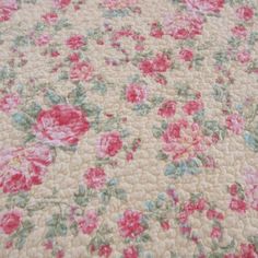 an old quilt with pink flowers on it