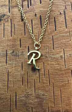 "Letter R necklace, set on a stainless steel ,golden color chain. Chain length 19'  With addition cost there is an option to add a white freshwater pearl, as a charm, next to the letter. 6 mm, white round pearl Kindly choose your option. Beautiful spiritual gift. Please make sure you to pay attention to the size of the pendant. I have added pictures next to 25 cent coin, and measurement tape.  Need a different length just write it to me in the \"message to the seller\" box of the order form. **L Gold R Necklace, R Pendant Letter Gold, R Necklace Letter, R Letter Necklace, R Wallpaper Letter Aesthetic, Letter R Necklace, R Initial Necklace, R Name, R Necklace