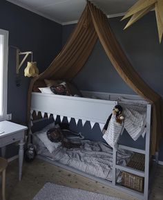 a child's bed with a canopy and stuffed animals