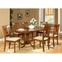 a dining room table with six chairs and a vase on the table in front of it