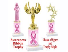 three trophies with pink ribbons on them and an angel statue in the middle one holding a star