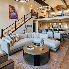 a living room filled with furniture next to a stair case on top of a hard wood floor