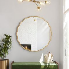 a living room with a green bench, mirror and potted plant