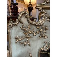 an ornate gold and white bed frame with flowers on it