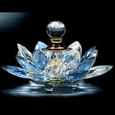 the perfume bottle is shaped like a flower and has crystal petals on its body, as well as a diamond cap