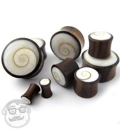 several wooden spools with white and brown tops on a white background, including one in the middle