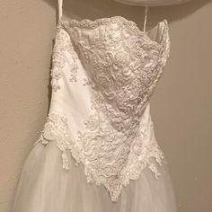 a wedding dress hanging on a hanger