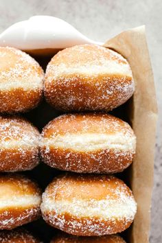 a box filled with lots of sugar covered donuts