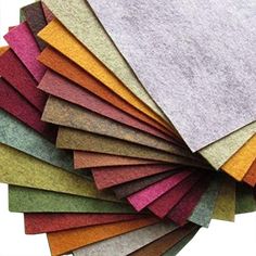 many different colored felts laid out on a cutting board