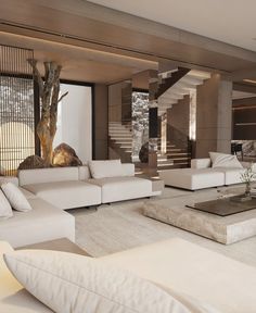 a modern living room with white couches and coffee table in front of the stairs