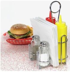 an open book sitting on top of a table next to a hamburger and salt and pepper shakers