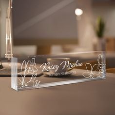 a clear glass award sitting on top of a wooden table next to a laptop computer