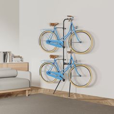 a blue bike mounted to the side of a white wall next to a gray couch