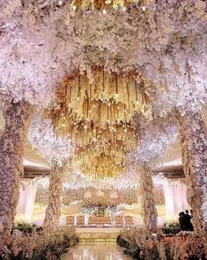 an instagram photo of a wedding venue with flowers and chandeliers hanging from the ceiling