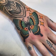 a hand with a butterfly tattoo on it