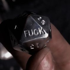 a close up of a person holding a metal dice