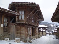 an old wooden house with snow on the ground